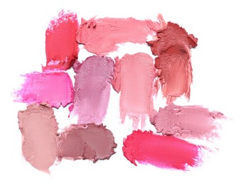 Smears of different bright lipsticks on white background, top view