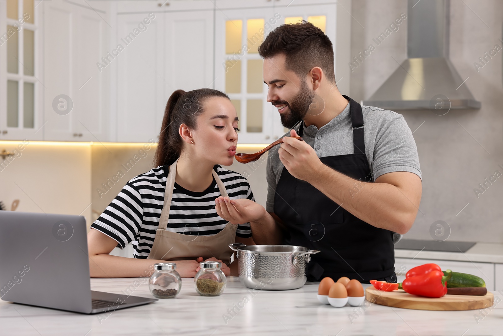 Photo of Lovely young couple cooking together in kitchen