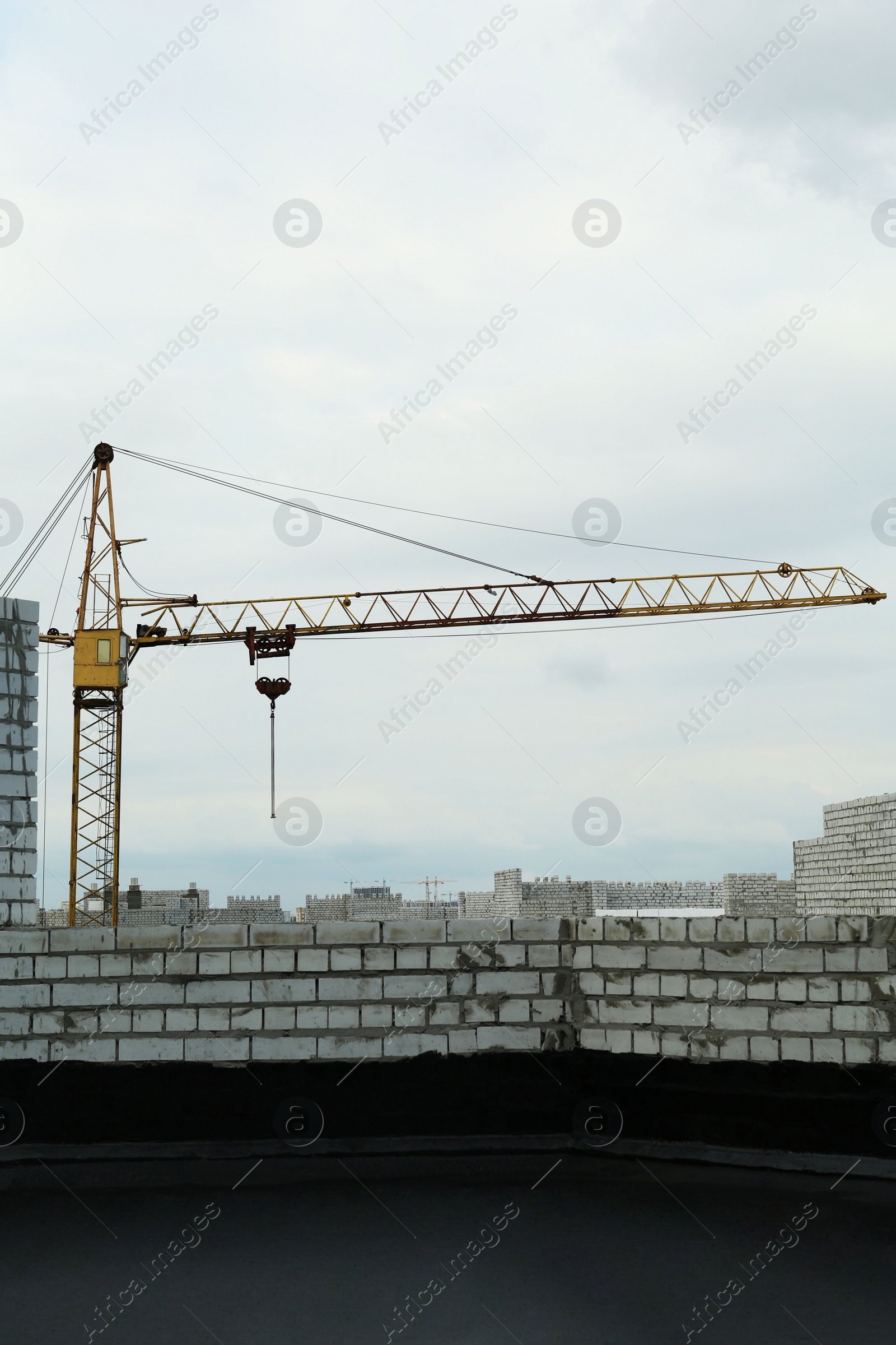 Photo of Construction site with tower crane near unfinished building