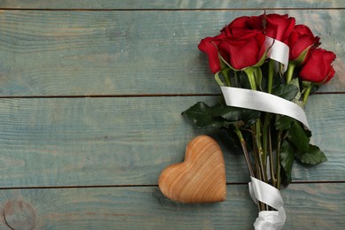 Photo of Beautiful red roses and decorative heart on blue wooden background, flat lay with space for text. Valentine's Day celebration