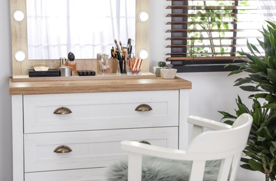 Photo of Dressing table with luxury cosmetics and accessories in room near window