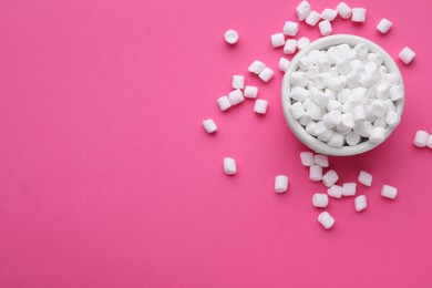 Bowl with delicious marshmallows on pink background, flat lay. Space for text