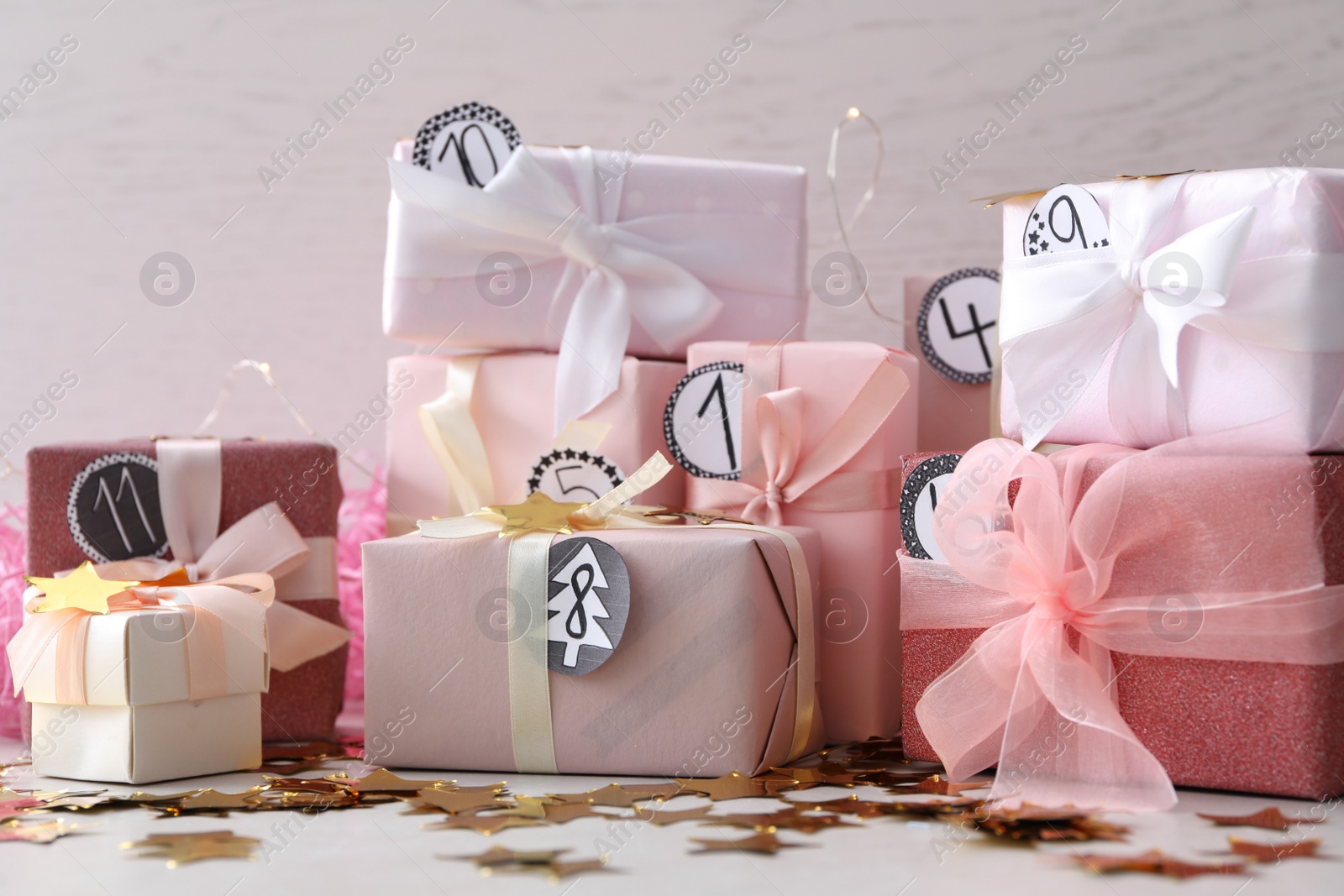 Photo of Gifts for Christmas advent calendar and confetti on white table