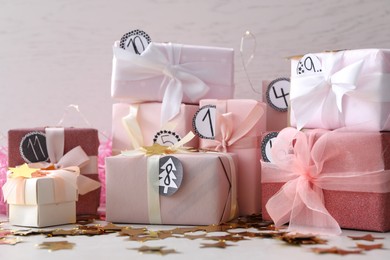 Gifts for Christmas advent calendar and confetti on white table