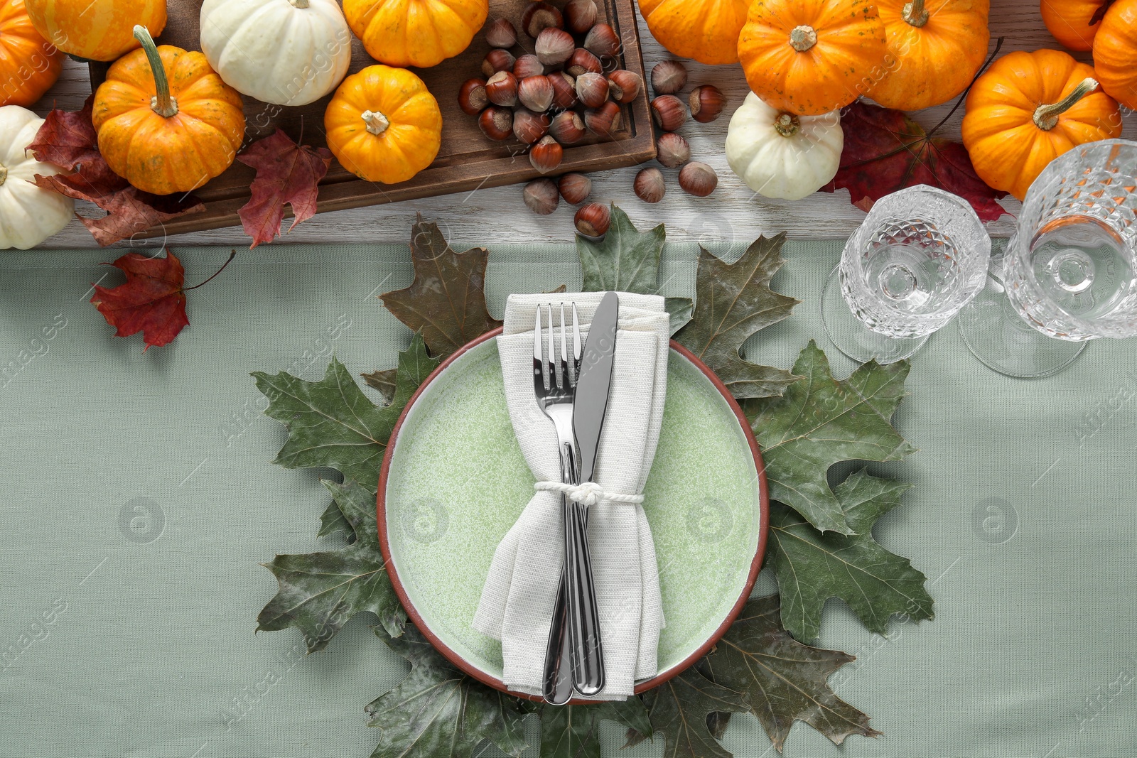 Photo of Happy Thanksgiving day. Beautiful table setting with autumn leaves, hazelnuts and pumpkins, flat lay