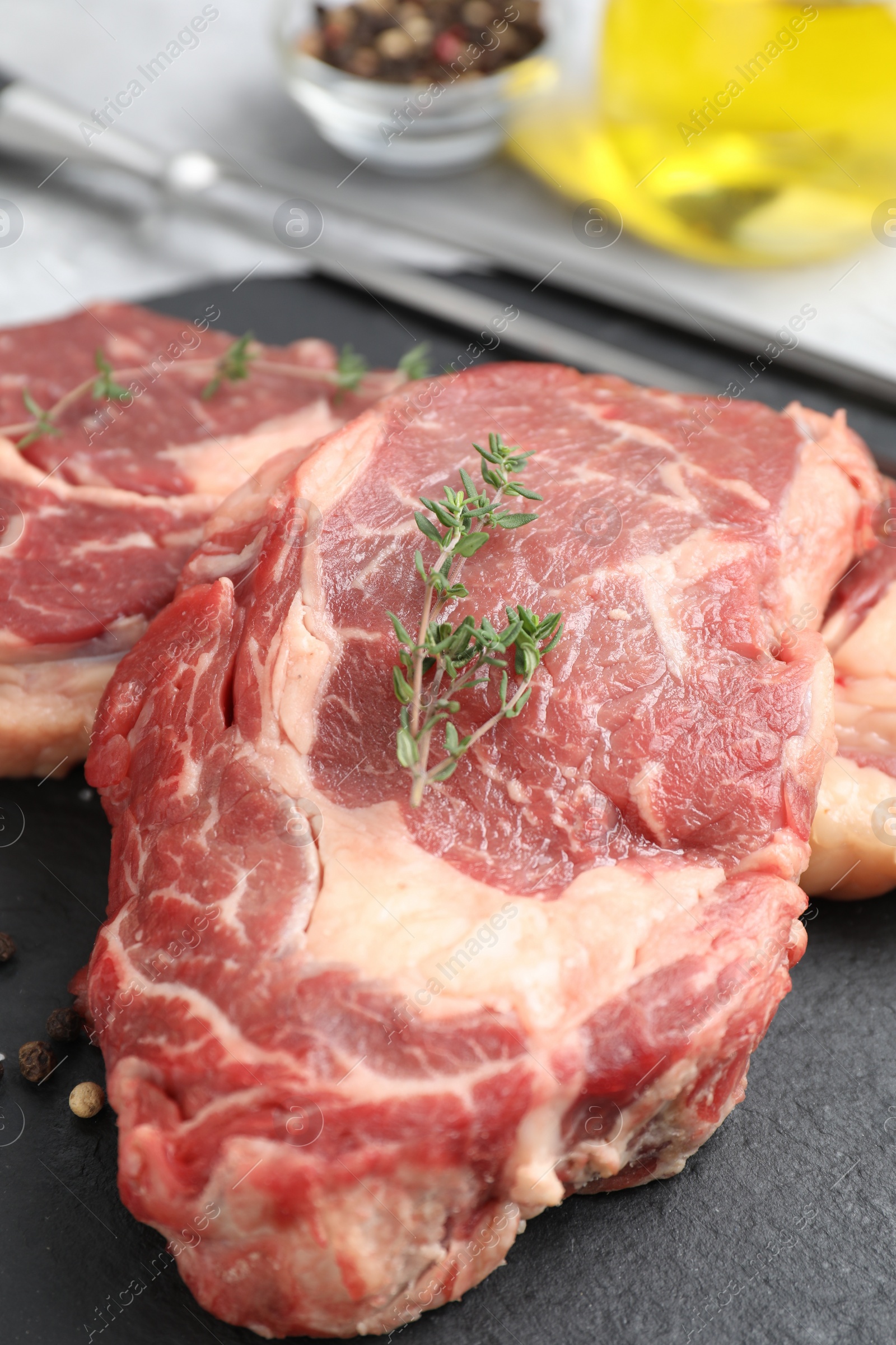 Photo of Fresh raw beef with thyme cut on table, closeup