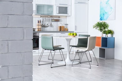 Photo of Stylish kitchen interior with dining table and chairs