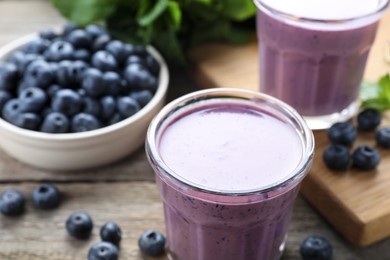Photo of Freshly made blueberry smoothie on wooden table, closeup
