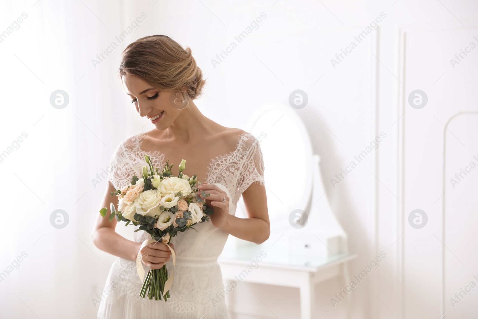 Photo of Bride in beautiful wedding dress with bouquet indoors. Space for text