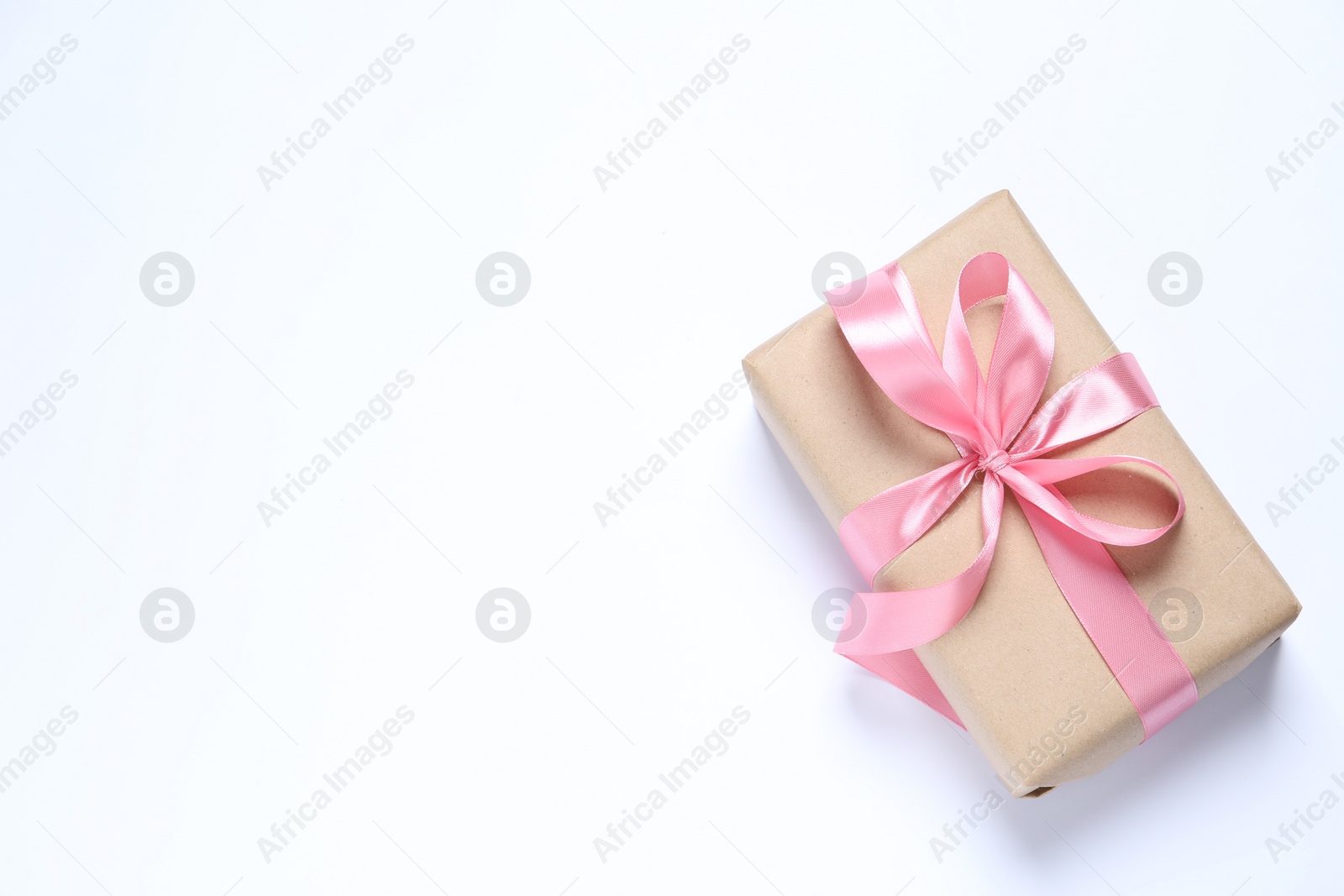 Photo of Beautiful gift box with pink bow on white background, top view. Space for text