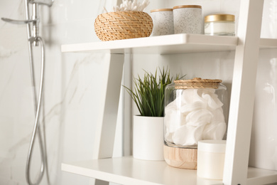 Shelving unit with toiletries in bathroom interior