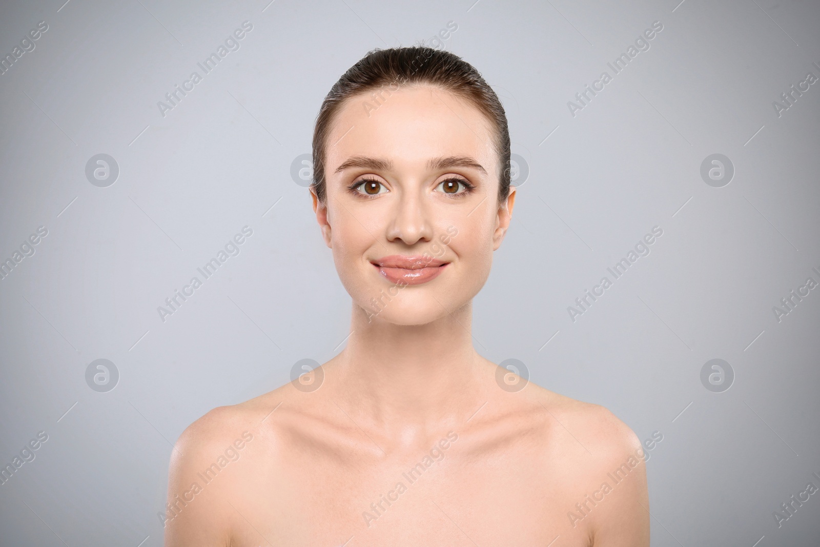 Photo of Portrait of beautiful young woman with perfect skin on grey background. Spa treatment