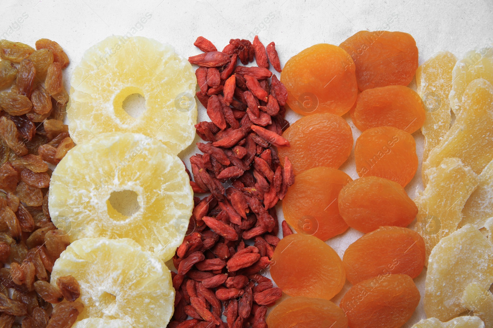 Photo of Different tasty dried fruits on paper, flat lay