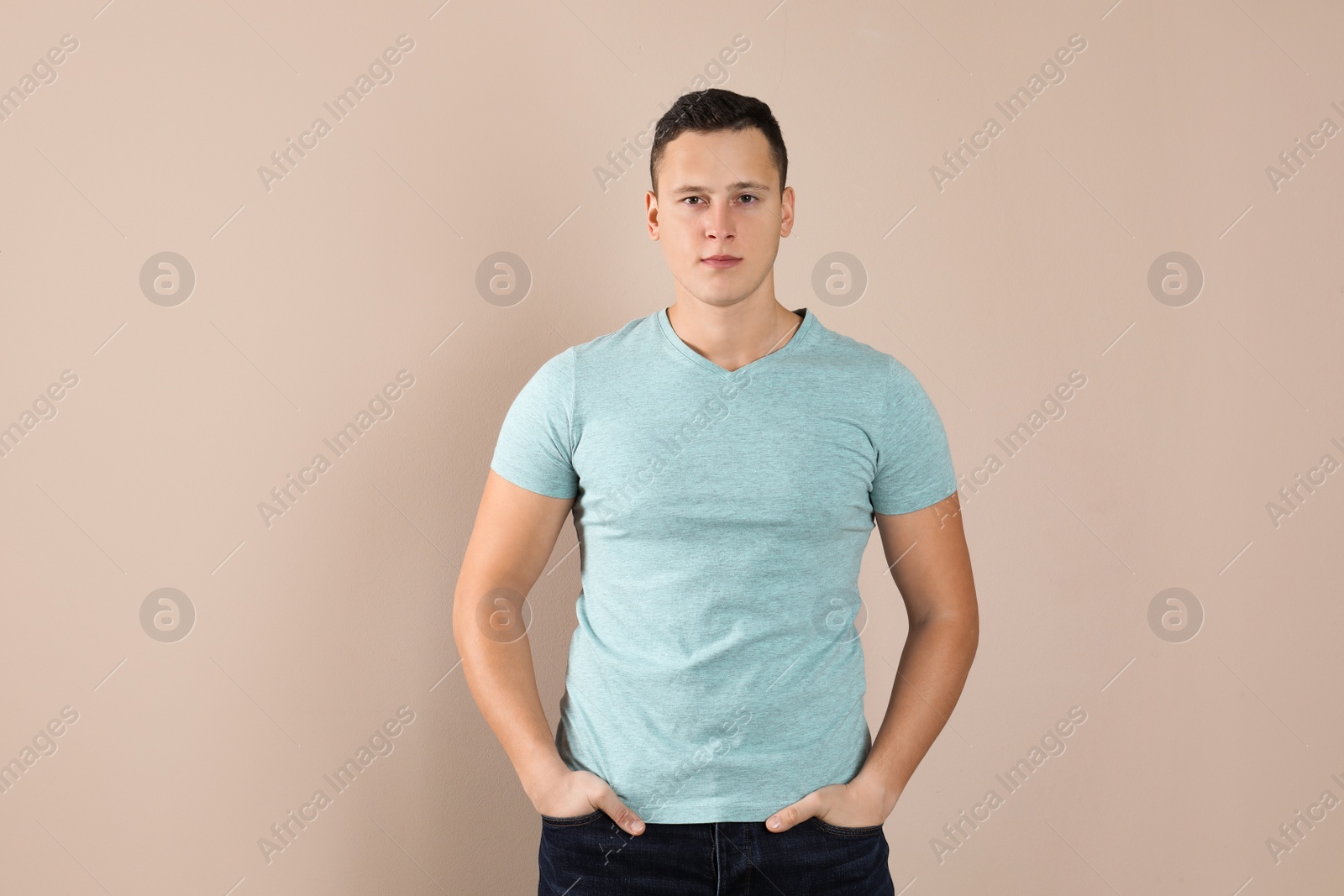 Photo of Confident handsome young man on beige background