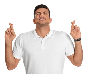 Photo of Man with crossed fingers on white background. Superstition concept