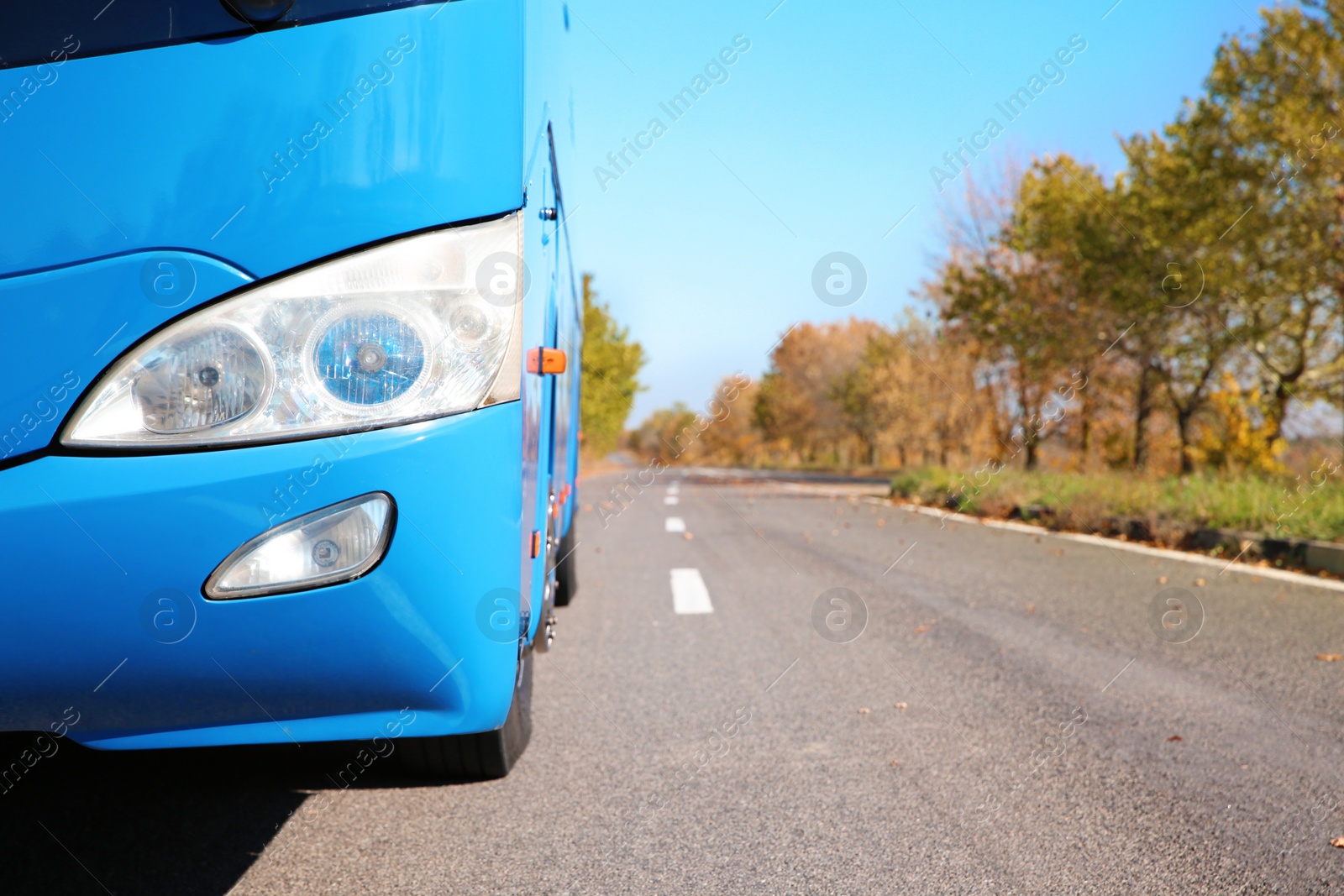 Photo of Modern blue bus on road, focus on headlight. Passenger transportation