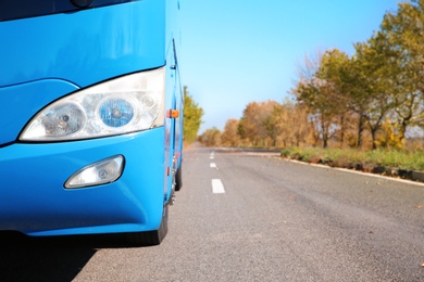 Modern blue bus on road, focus on headlight. Passenger transportation