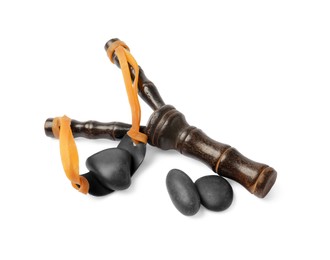 Photo of Black wooden slingshot with stones on white background