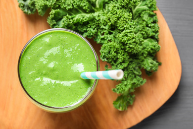 Photo of Tasty kale smoothie on wooden table, flat lay