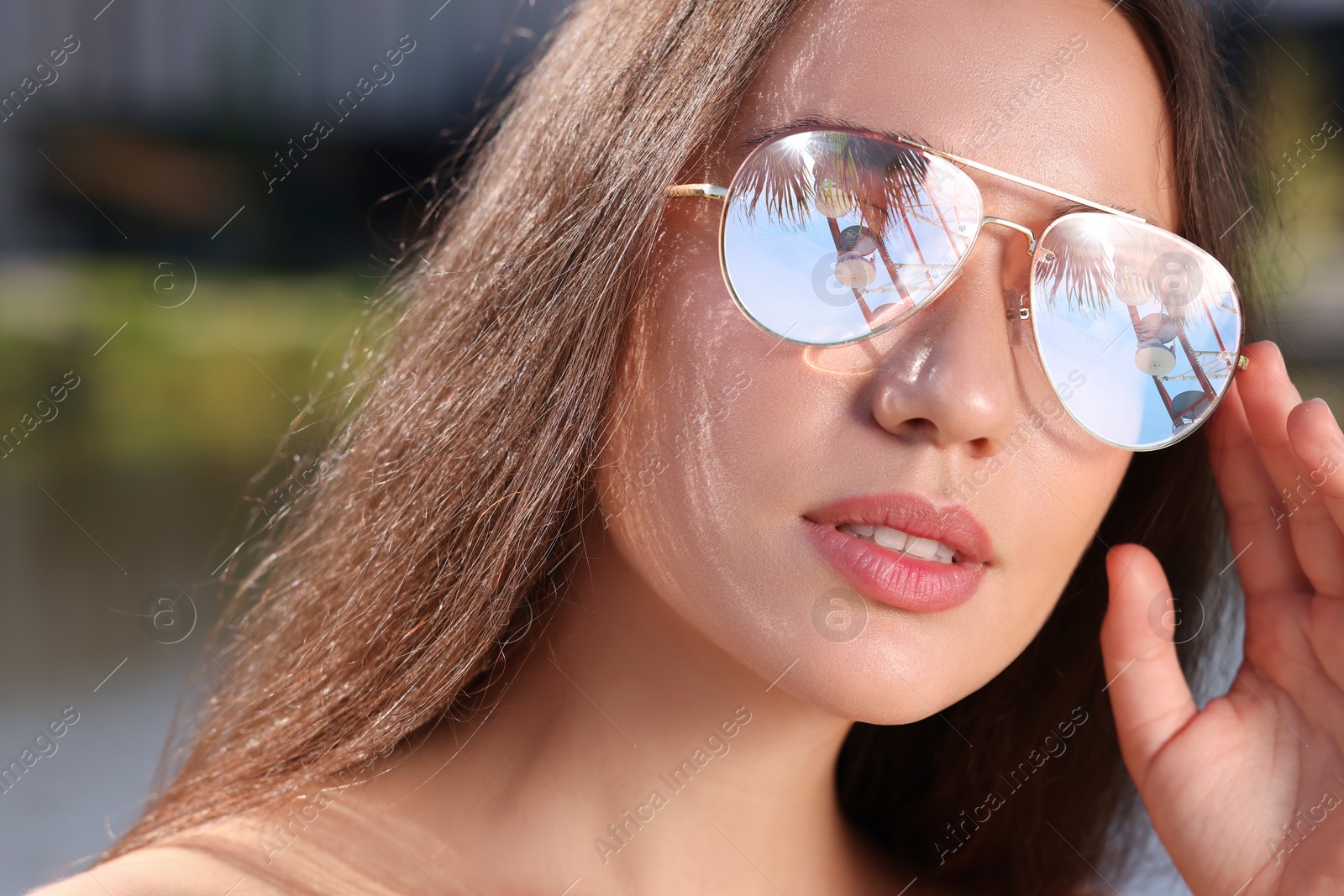 Image of Beautiful woman in sunglasses on sunny day outdoors. Sky, palm tree and observation wheel reflecting in lenses