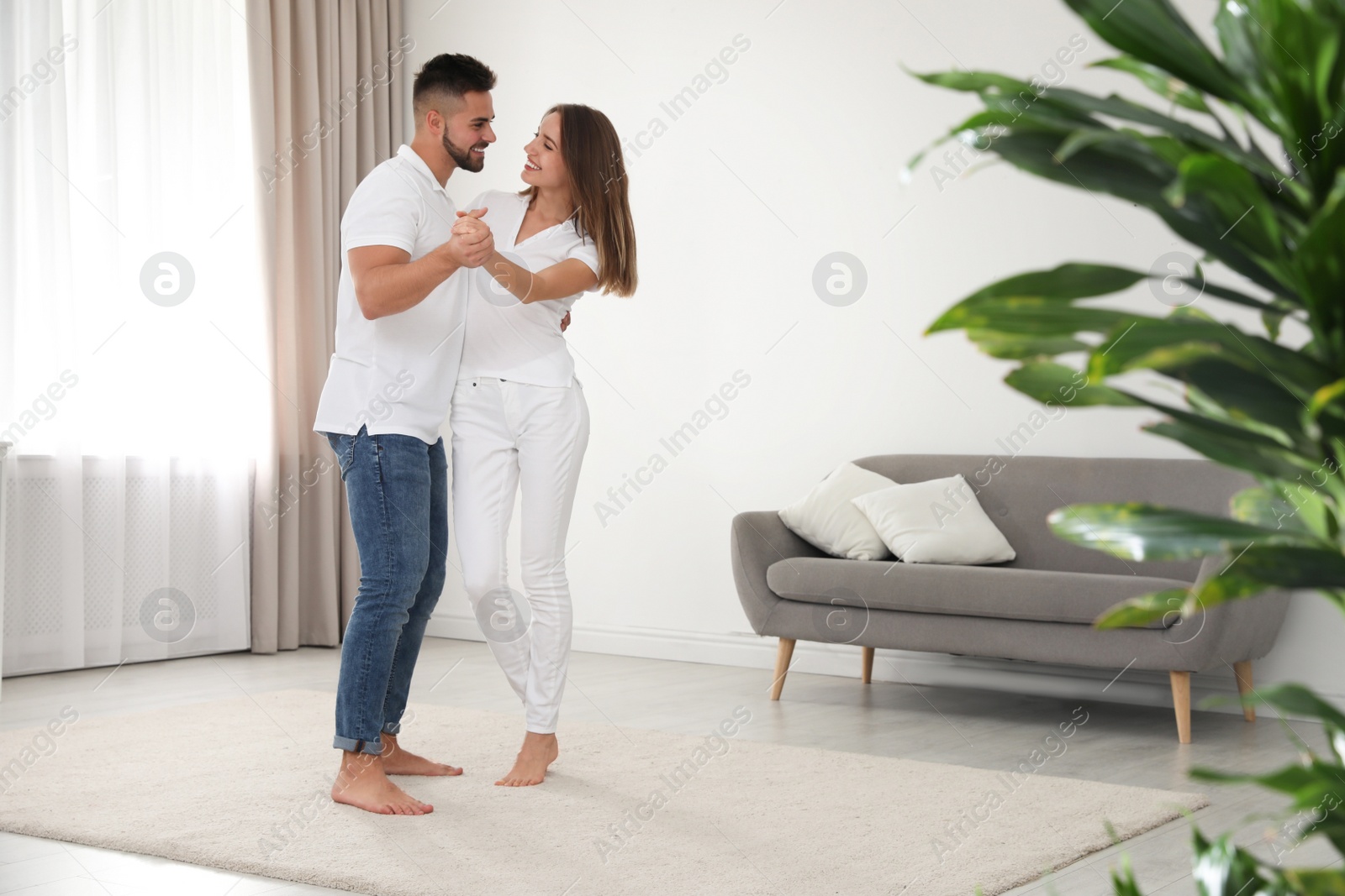 Photo of Lovely young couple dancing together at home