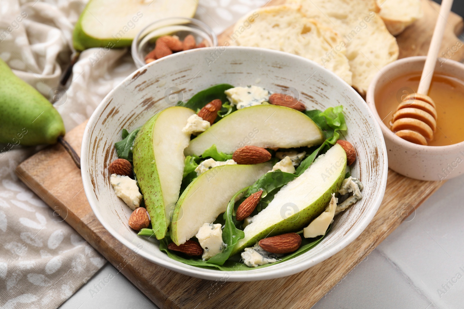 Photo of Delicious pear salad in bowl on light table, closeup