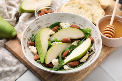 Photo of Delicious pear salad in bowl on light table, closeup