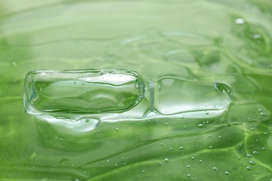 Pharmaceutical ampoule with medication in transparent gel on green background, closeup