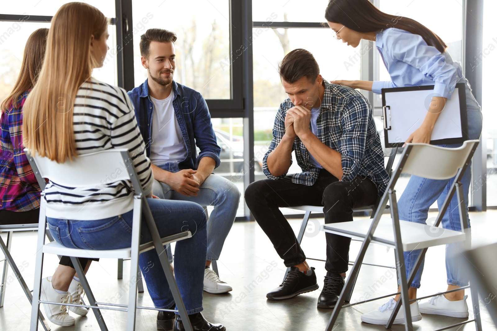 Photo of Psychotherapist working with patients in group therapy session indoors