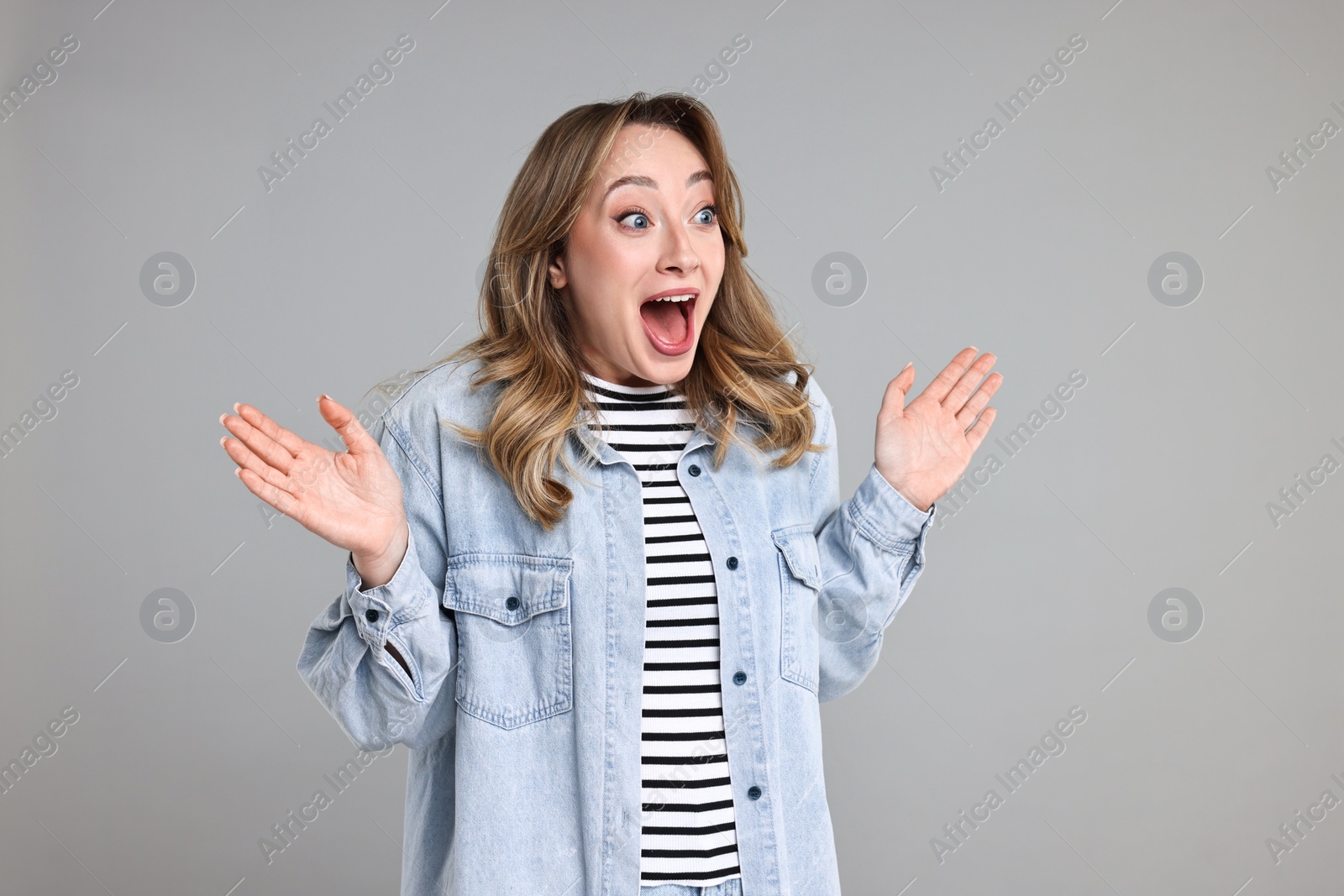 Photo of Portrait of surprised woman on grey background