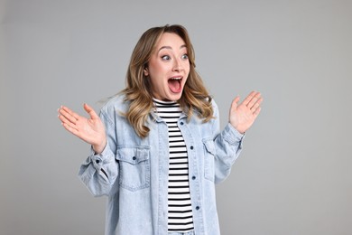 Portrait of surprised woman on grey background