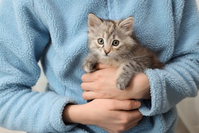 Photo of Woman holding cute fluffy kitten, closeup view