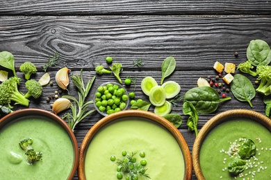 Flat lay composition with different fresh vegetable detox soups made of green peas, broccoli and spinach in dishes on table. Space for text