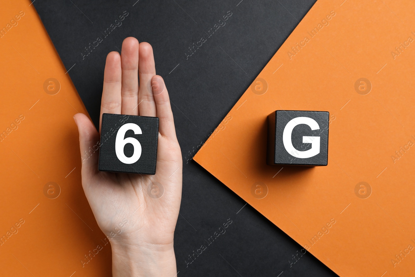 Photo of 6G technology, Internet concept. Woman with black wooden cubes on color background, top view