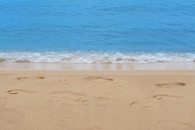 Photo of Sandy beach with footprints near beautiful sea