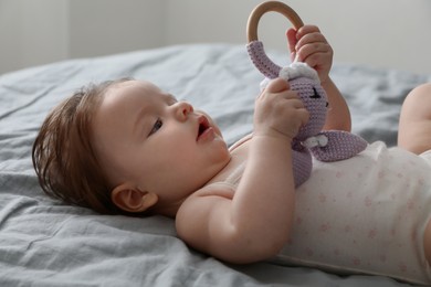 Photo of Cute little baby with toy on bed