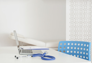 Photo of Doctor's workplace with modern laptop in medical office