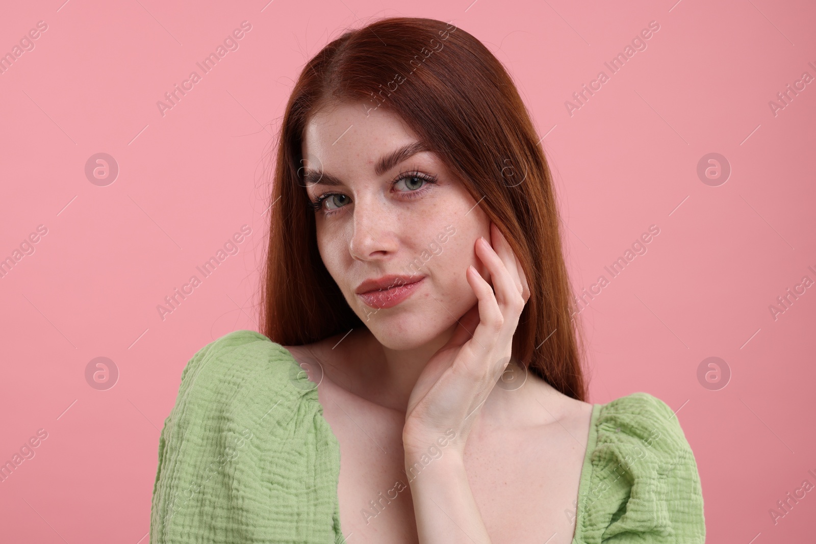 Photo of Portrait of beautiful woman with freckles on pink background