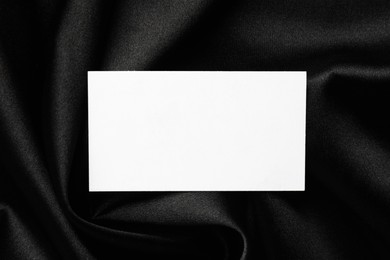 Photo of Blank business card on black fabric, top view. Mockup for design