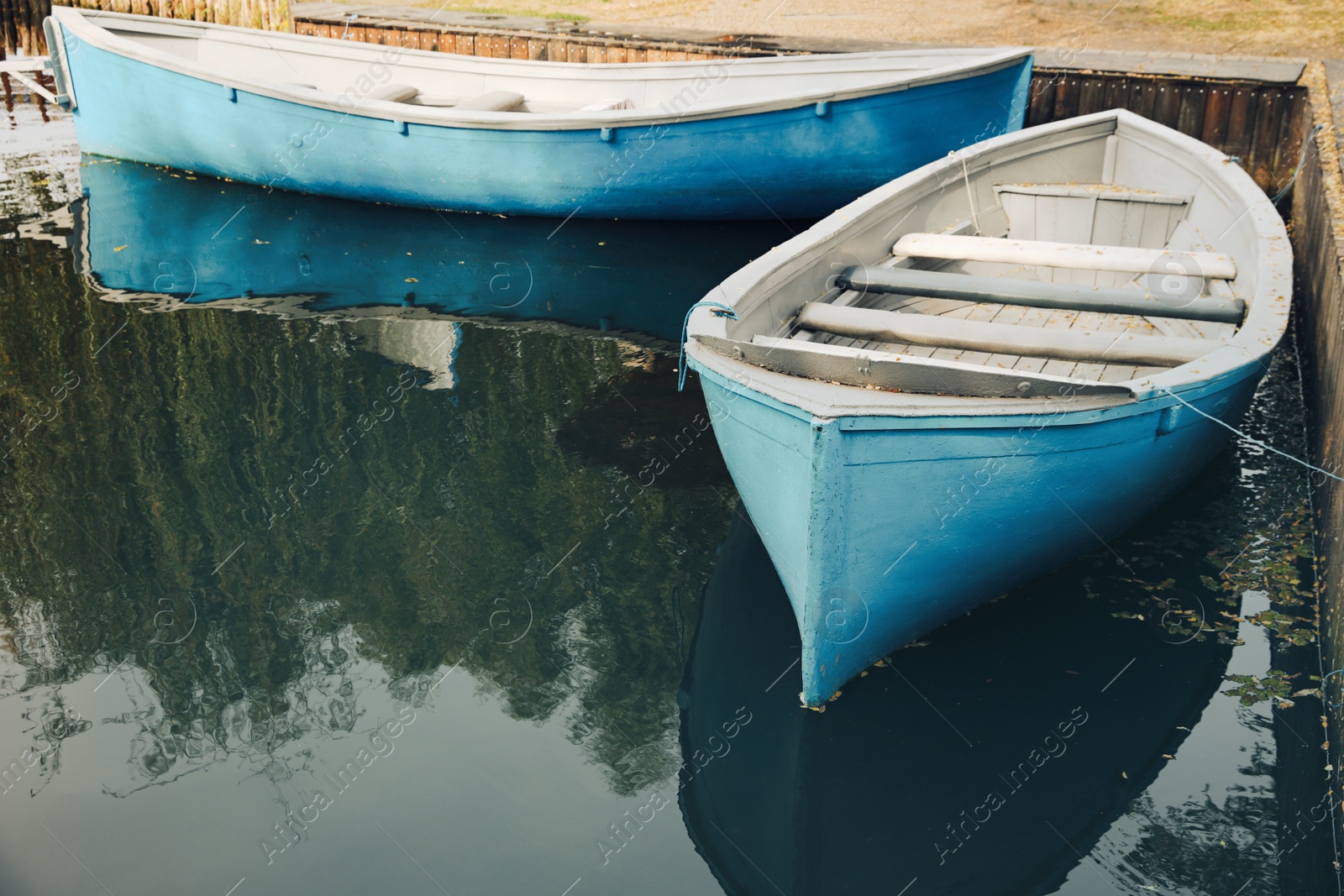 Photo of Light blue wooden boats on river, space for text