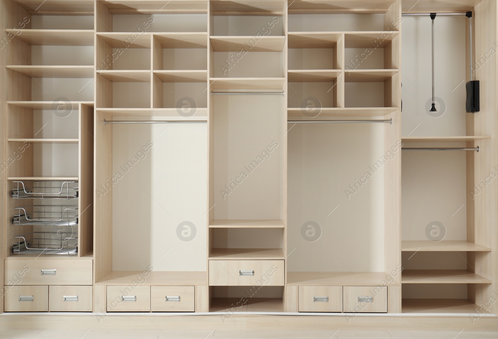 Photo of Empty wooden wardrobe with shelves and drawers in dressing room