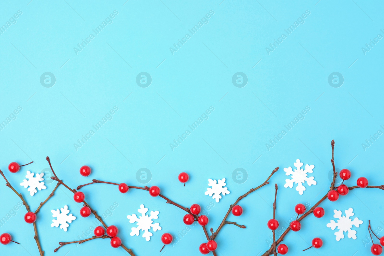 Photo of Winter composition with decorative branches on light blue background, flat lay. Space for text