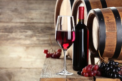 Winemaking. Composition with tasty wine and barrels on wooden table, space for text