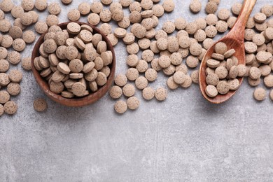 Brewer's yeast tablets on grey table, flat lay. Space for text