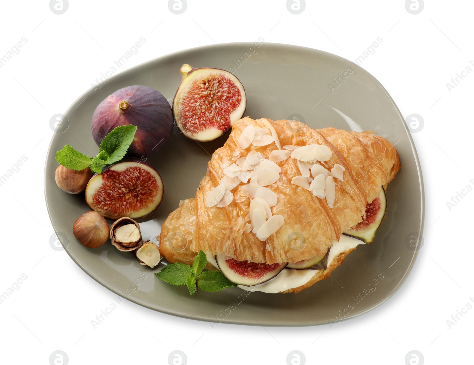 Photo of Delicious croissant with cream cheese, figs and hazelnuts isolated on white, top view