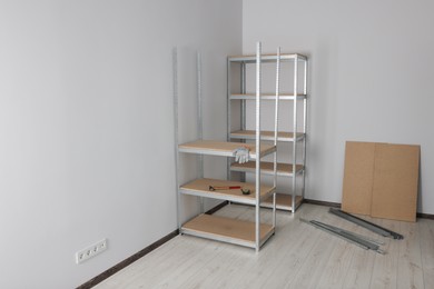 Photo of Office room with white walls and metal storage shelves. Space for text