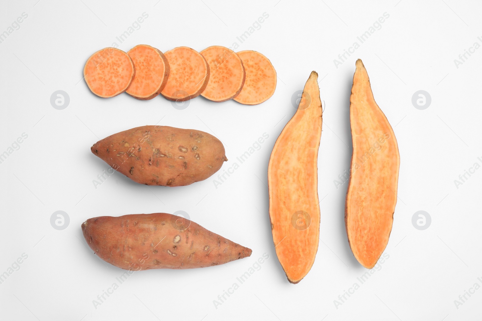 Photo of Cut and whole sweet potatoes on white background, top view