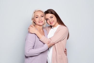 Photo of Portrait of mature woman and her daughter on color background