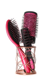 Set of hairbrushes in holder on white background