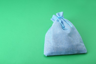 Photo of Tied burlap bag on green background. Space for text